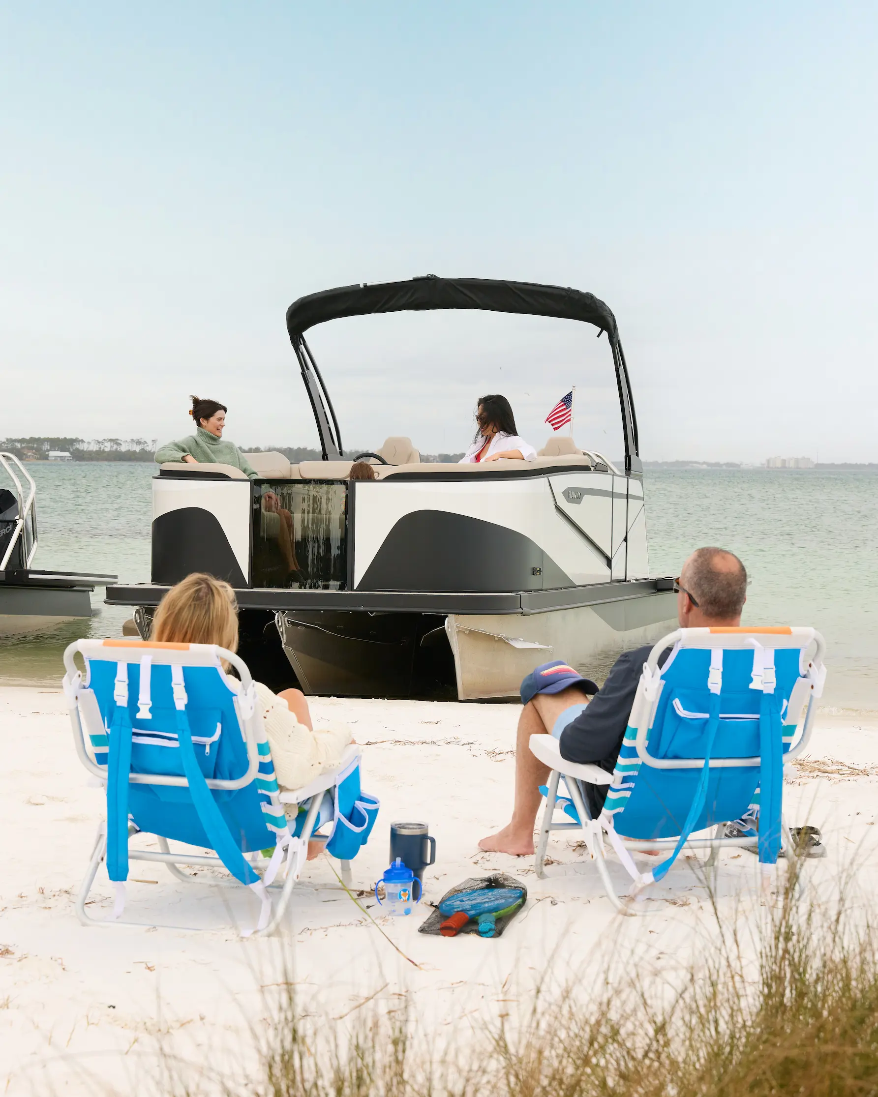 Two lounge chairs on the shore beside a beached Flamingo ROVE