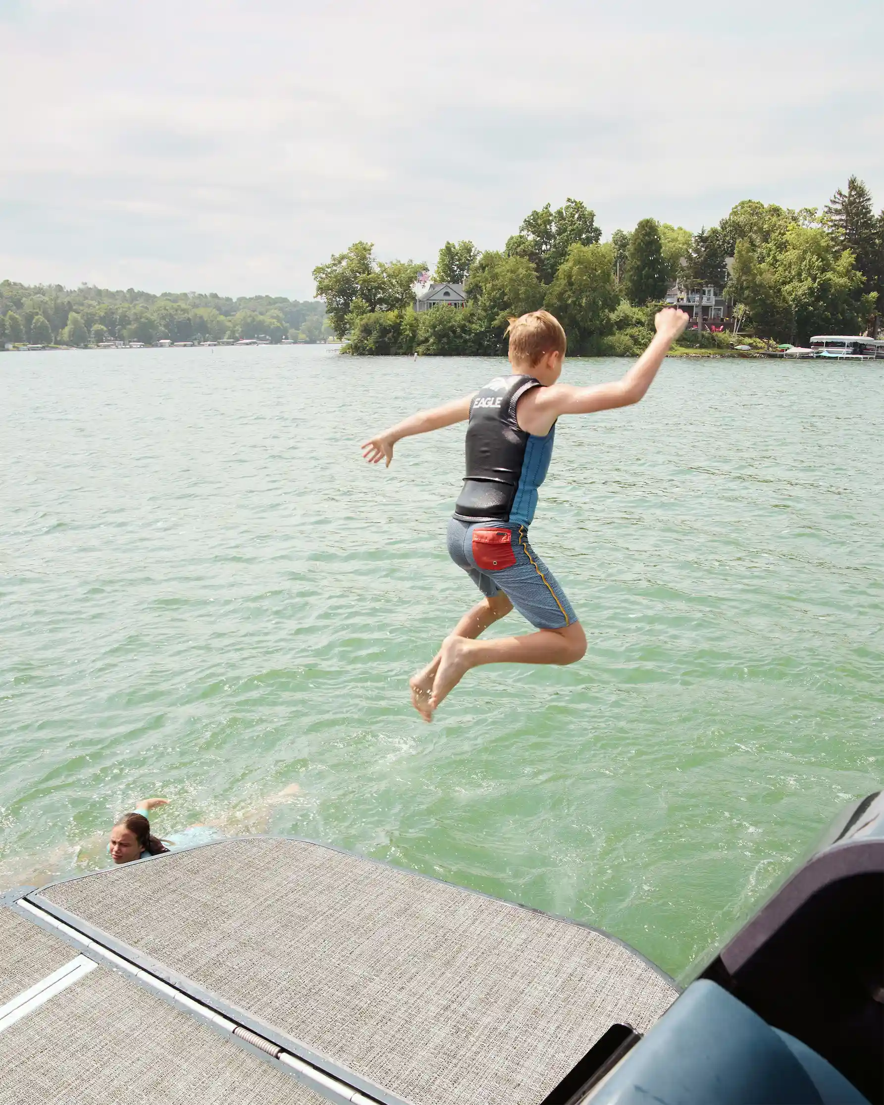 A young person leaping off the Flamingo ROVE's wing into the lake